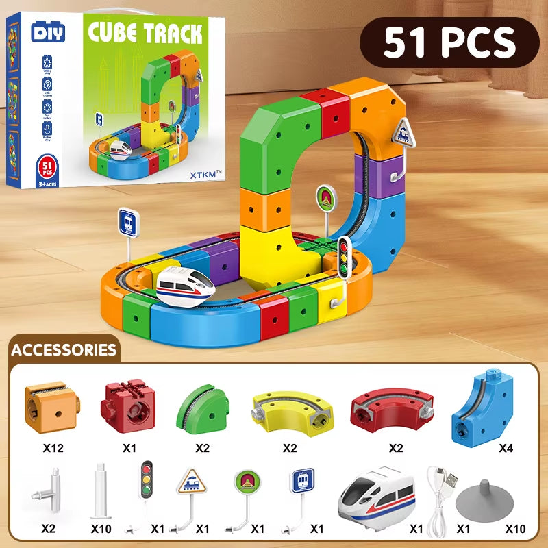 Colorful toy track set with accessories on a wooden surface, including packaging and small train model.